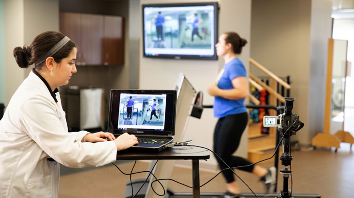 MCPHS physical therapy student monitoring a running patient's progress through her laptop