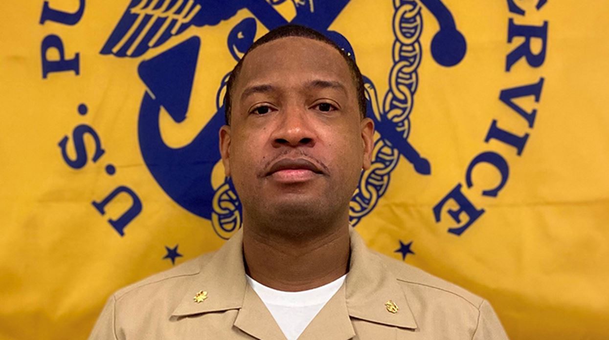 Portrait photo of Steven Rush in front of United States Public Health Service flag